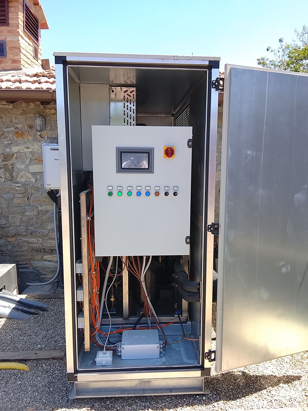 Vano quadro della centrale aperto, con il pannello di comando e i cablaggi